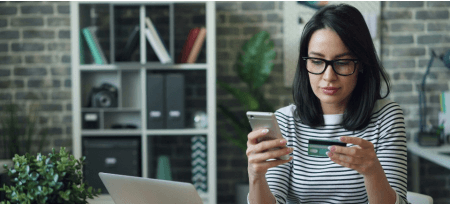 Una donna esegue un acquisto online con smartphone e carta di credito