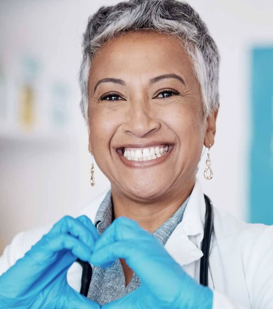 Donna medico sorridente con le mani unite a formare un cuore